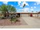 Charming single-story home featuring a two-car garage, desert landscaping, and a lush, green tree in the front yard at 3926 W Christy Dr, Phoenix, AZ 85029