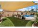Inviting backyard pool area with artificial turf, shade cover, and desert landscaping, perfect for relaxing or entertaining at 3926 W Christy Dr, Phoenix, AZ 85029