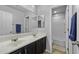 Well-lit bathroom with double sinks, modern vanity and combination shower/tub at 40893 W Bedford Dr, Maricopa, AZ 85138