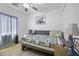 Comfortable bedroom with a full bed, wood flooring, soft lighting and ample space at 40893 W Bedford Dr, Maricopa, AZ 85138