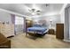 Lovely bedroom with ceiling fan, bed and furniture set against a brick accent wall at 40893 W Bedford Dr, Maricopa, AZ 85138