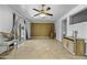 Open living area boasting tile floors, brick feature wall, ceiling fan, and sliding glass door at 40893 W Bedford Dr, Maricopa, AZ 85138