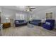 Bright living room with hardwood floors, ample natural light, and comfortable blue sofas at 40893 W Bedford Dr, Maricopa, AZ 85138