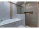 Modern bathroom with a soaking tub, glass-enclosed shower, and tiled walls at 4116 E Sunnyside Dr, Phoenix, AZ 85028