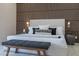 Modern bedroom featuring wood-slat accent wall, neutral color palette, and shuttered windows at 4116 E Sunnyside Dr, Phoenix, AZ 85028
