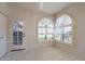 Bright room with two arched windows with shutter blinds and a door leading outside at 4116 E Sunnyside Dr, Phoenix, AZ 85028
