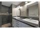 Bathroom featuring dual sinks with white cabinets and modern tiled walk-in shower at 4248 N Parkway Ave, Scottsdale, AZ 85251