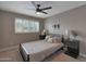 Comfortable bedroom featuring a bed with striped bedding, two nightstands, a ceiling fan, and plantation shutters at 4248 N Parkway Ave, Scottsdale, AZ 85251