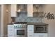 Close up of a kitchen cooktop with stainless steel appliances and a decorative backsplash at 4248 N Parkway Ave, Scottsdale, AZ 85251