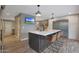 Kitchen island with seating, wood floors, and open view of living area at 4248 N Parkway Ave, Scottsdale, AZ 85251