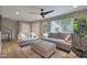 Bright living room with wood floors, gray couches, a ceiling fan, and large windows offering plenty of natural light at 4248 N Parkway Ave, Scottsdale, AZ 85251