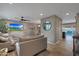 Spacious living room with wood floors, modern lighting, a gray sofa, and an open layout to the kitchen at 4248 N Parkway Ave, Scottsdale, AZ 85251