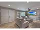 Cozy living room with comfortable gray couches, a ceiling fan, a television, and plenty of natural light at 4248 N Parkway Ave, Scottsdale, AZ 85251