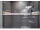 Walk-in shower featuring gray tile, stone accents and rainfall shower head at 4248 N Parkway Ave, Scottsdale, AZ 85251
