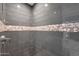 The walk-in shower features modern tile and a decorative stone accent stripe at 4248 N Parkway Ave, Scottsdale, AZ 85251