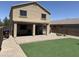 Well-maintained backyard showcasing artificial turf, a brick patio, a covered patio and views of neighboring properties at 42775 W Jeremy St, Maricopa, AZ 85138