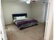 Simple bedroom with a blue upholstered bed, neutral walls, and carpet flooring at 42775 W Jeremy St, Maricopa, AZ 85138