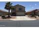 Inviting two-story home featuring a two-car garage, desert landscaping, and a mature palm tree in the front yard at 42775 W Jeremy St, Maricopa, AZ 85138