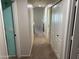 Neutral-toned hallway featuring carpet flooring, access to multiple rooms, and closet space at 42775 W Jeremy St, Maricopa, AZ 85138
