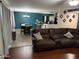 Comfortable living room with a brown leather sofa, opening into a dining area and kitchen space at 42775 W Jeremy St, Maricopa, AZ 85138