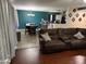 Comfortable living room with a brown leather sofa, opening into a dining area and kitchen space at 42775 W Jeremy St, Maricopa, AZ 85138
