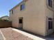 Exterior view featuring the side of a tan home, gravel landscaping, and a partial view of the backyard at 42775 W Jeremy St, Maricopa, AZ 85138
