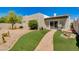 Well-maintained backyard with green turf, brick-paved walkway, and established landscaping at 4317 E Glenrosa Ave, Phoenix, AZ 85018