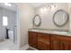 Bathroom featuring double sinks with stone countertops, dark wood cabinets, and a soaking tub at 4317 E Glenrosa Ave, Phoenix, AZ 85018