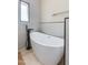 Modern bathroom featuring light tiles, a soaking tub, and a matte black faucet at 4317 E Glenrosa Ave, Phoenix, AZ 85018