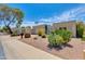 Street view of single-story home featuring a two car garage, mature landscaping, and blue sky background at 4317 E Glenrosa Ave, Phoenix, AZ 85018