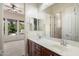 Bathroom with dual sinks and large mirror reflecting bedroom at 43998 W Palo Abeto Dr, Maricopa, AZ 85138