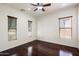 Well-lit bedroom with hardwood floors and multiple windows, providing ample natural light at 43998 W Palo Abeto Dr, Maricopa, AZ 85138