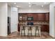 Bright kitchen featuring dark wood cabinets, stainless steel appliances, and a breakfast bar with seating at 43998 W Palo Abeto Dr, Maricopa, AZ 85138