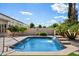 Pool with waterfall feature set in a private backyard with mature trees and lush green landscaping at 43998 W Palo Abeto Dr, Maricopa, AZ 85138