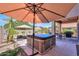 Lush backyard with a spa, pool, lounge chairs, and a barbecue, for ultimate outdoor leisure at 44158 W Cypress Ln, Maricopa, AZ 85138