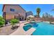 Landscaped backyard featuring a pool, seating areas, and mature trees for shade and privacy at 44158 W Cypress Ln, Maricopa, AZ 85138