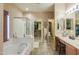 Bright bathroom featuring a bathtub, vanity, and a walk-in closet at 44158 W Cypress Ln, Maricopa, AZ 85138