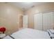 Neutral bedroom featuring a double-door closet and an adjacent bathroom at 44158 W Cypress Ln, Maricopa, AZ 85138