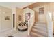 Inviting entryway with carpeted stairs, a round chair, and decorative artwork adding warmth to the space at 44158 W Cypress Ln, Maricopa, AZ 85138