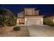 Charming two-story home with a well-manicured front yard and attached two-car garage at night at 44158 W Cypress Ln, Maricopa, AZ 85138
