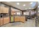 Functional kitchen area with stainless steel appliances, light wood cabinetry, and an open view to the dining space for easy interaction at 44158 W Cypress Ln, Maricopa, AZ 85138