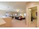 Open-concept living room with a comfortable sectional couch and large windows at 44158 W Cypress Ln, Maricopa, AZ 85138