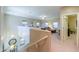 Spacious loft area with multiple windows, a comfortable sofa, and views of the downstairs area at 44158 W Cypress Ln, Maricopa, AZ 85138