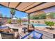 Relaxing outdoor living area with comfortable seating, overlooking a pool and well-manicured landscape at 44158 W Cypress Ln, Maricopa, AZ 85138