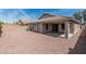 Desert landscaped backyard with covered patio and tan colored home at 708 E Mule Train Trl, San Tan Valley, AZ 85143