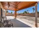 The backyard patio has an ornate wood roof and a chair set, while the lawn is covered with sparse growth at 7239 E Madero Ave, Mesa, AZ 85209