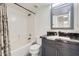 Bathroom features a shower-tub combo, toilet and modern vanity with a black countertop, offering a clean and stylish space at 7239 E Madero Ave, Mesa, AZ 85209