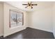 Bright bedroom featuring a ceiling fan and a large window providing natural light and street views at 7239 E Madero Ave, Mesa, AZ 85209