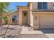Welcoming front entrance with decorative pillars, desert landscaping, and a two-car garage on the side at 7239 E Madero Ave, Mesa, AZ 85209