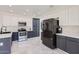 Modern kitchen featuring stainless steel appliances, white cabinets, and stylish dark gray lower cabinets at 7239 E Madero Ave, Mesa, AZ 85209